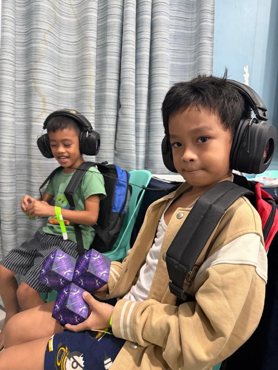 Crianças participantes da missão da GC Rivera Foundation, usando fones de ouvido